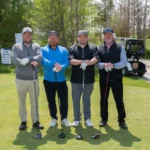 4 male golfers resting on drivers